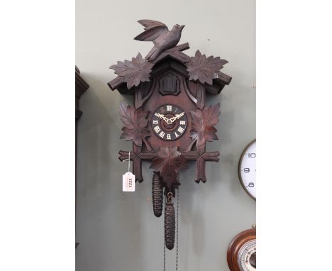 A 20th Century Black Forest style wall mounted, twin weight cuckoo clock, the case with bird and leaf decoration to a chapter