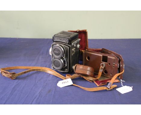 A Beautyflex TLR camera, No.90388, together with stitched leather case (stitching as found) and a cased Rollei sun shade