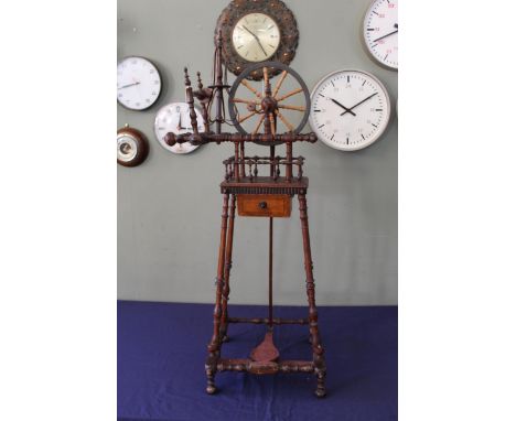 An early 19th Century small bobbin turned spinning wheel, with rebuilt and brass bound wheel and hand crank to a screw adjust
