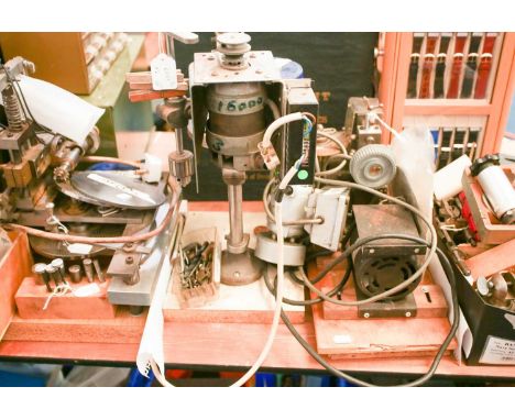 A vintage clockmakers wheel/ gear cutting mill with electric, belt-driven power source. Together with a benchtop, watchmakers