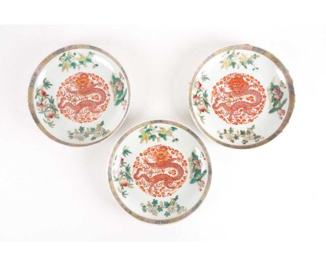 A set of three Chinese Famille rose porcelain circular, dragon dishes. Qing dynasty. Each painted with an iron red, central p