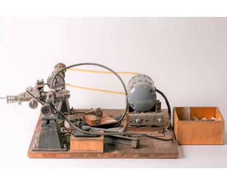 A vintage "Pultra" 18" watchmaker/model makers lathe with belt-driven power source and some tooling. Mounted on a benchtop ba