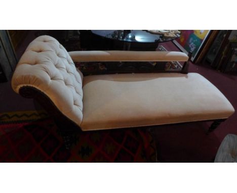 An Art Nouveau mahogany chaise lounge, with beige button back velour upholstery, raised on turned legs and castors 