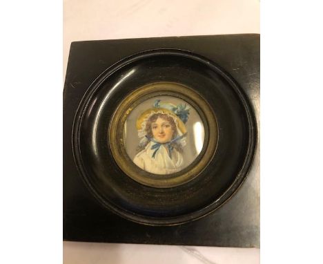 A 19th century portrait miniature of a lady with wearing a bonnet, framed and glazed, Diameter 5cm