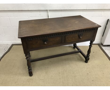 An oak two drawer side table in the 17th Century style, raised on baluster turned and ringed supports united by a centre stre