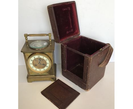 A large carriage style clock, the top with swing handle and silvered dial, compass and mercury thermometer inscribed "Reaumur