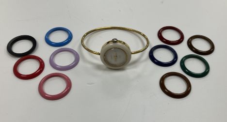 A Gucci gold-plated bangle watch with eleven interchangeable coloured plastic bezels (NB no box or paperwork), together with 