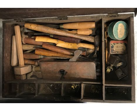 A wooden box with paper label inscribed “Captain Dawes …” the hinge lid opening to reveal a collection of vintage wooden hand