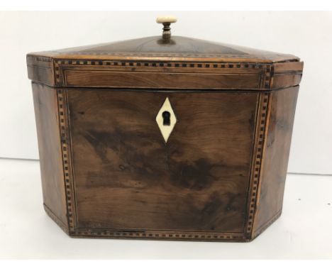 An early 19th Century yew wood and inlaid elongated octagonal tea caddy, the top opening to reveal two lidded compartments, 1