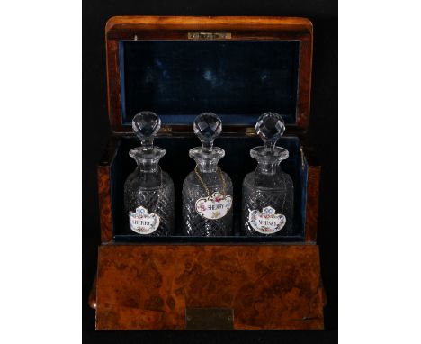 Walnut cased three decanter box with lift lid and fall front, lined in blue velvet, the three bottles hobnail cut, ceramic la