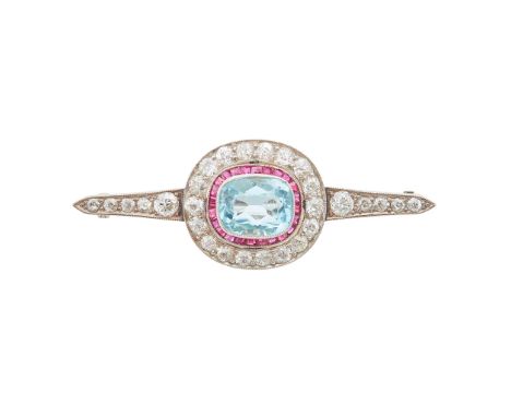 millegrain set with a cushion-cut aquamarine in a border of channel set rubies and old round-cut diamonds, each shoulder set 