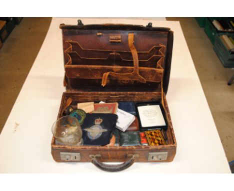 A vintage case containing a cloth badge, Tunbridge ware card case, travelling clocks, Parker pens etc.