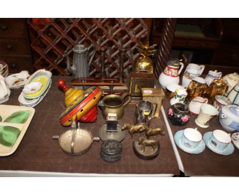 A vintage child's tin spinning top decorated with Disney characters, mantle clock, pair of brass candlesticks, brass jar in t