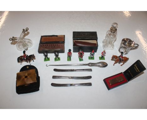 A box containing silver handled butter knives, silver handle button hook, silver mounted oil and vinegar bottle, model soldie