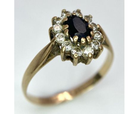 A Vintage 9K Yellow Gold Diamond and Sapphire Ring. Central sapphire with a diamond halo. Size N. 1.62g total weight. 