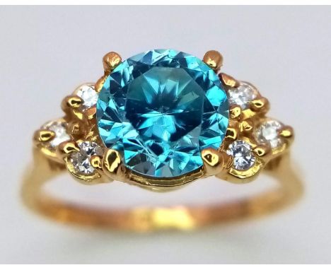 A BLUE ZIRCON GEMSTONE FLANKED BY 6 SMALL DIAMONDS SET IN 18K GOLD .. A VERY PRETTY RING! 2.8gms size L