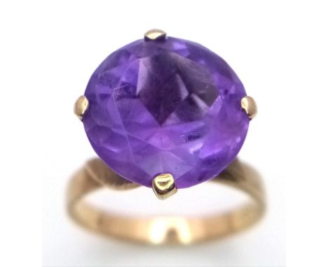 A Vintage 9K Yellow Gold Amethyst Ring. Large round cut amethyst in a raised setting. Size J. 3.62g weight.