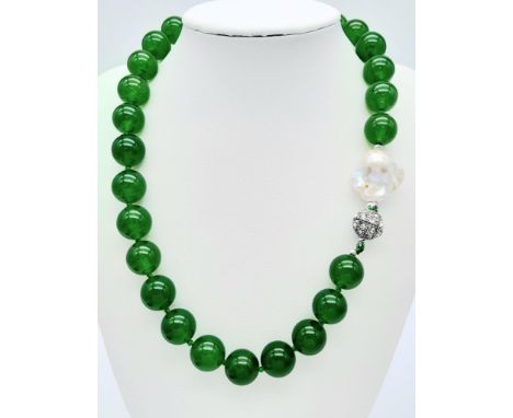 A Green Jade and Keisha Baroque Pearl Necklace. 14mm green jade beads with a baroque pearl interrupter. Glitterball clasp. 44