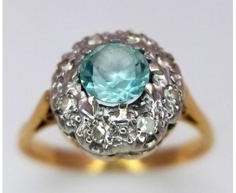 A Vintage 18K Yellow Gold Aquamarine and Diamond Ring. Central aquamarine with a diamond halo. Size N. 3.36g total weight. 