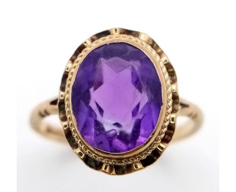 A VINTAGE 9K YELLOW GOLD AMETHYST RING - 2.4CT FACETED OVAL AMETHYST SOLITAIRE STONE- 2.3G TOTAL WEIGHT - SIZE K 