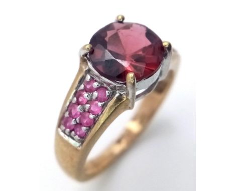 A 9K Yellow Gold Garnet and Ruby Ring. Central garnet with ruby accents. Size K. 3.05g total weight. 