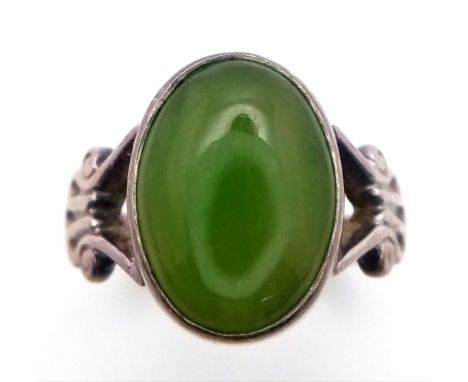 A vintage silver cabochon Jade solitaire ring with further decoration on shoulder. Total weight 4.6G. Size Q 