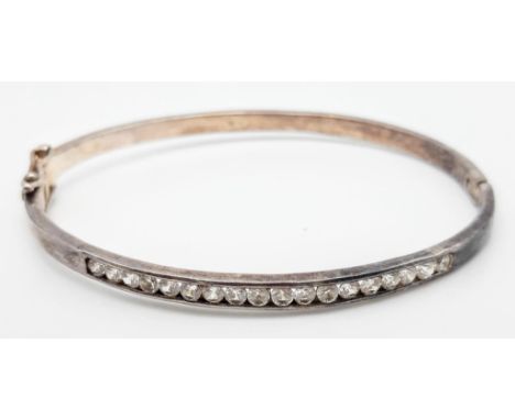 A vintage 925 silver stone set click-on bangle. Total weight 12.6G. Diameter 6.5cm.