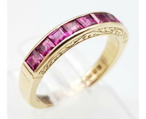 A 9K GOLD CHANNEL SET RUBY BAND RING .  2.5gms   size J 