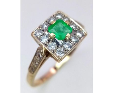 A VERY ATTRACTIVE 9K GOLD RING WITH CENTRAL EMERALDSURROUNDED BY WHITE ZIRCON STONES . 3.3gms size V
