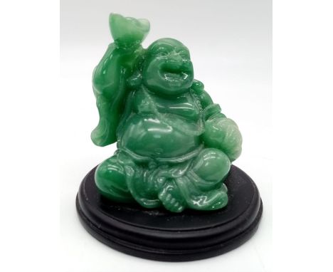 A GREEN JADE AMITABHA BUDDHA , SMILING AND BRINGING JOY AND HAPPINESS SEATED ON A BLACK HARDWOOD PLINTH . 7 cms in height 