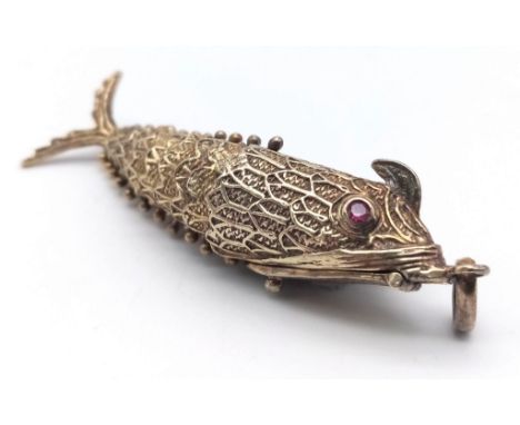 A vintage sterling silver articulated fish pendant with Ruby eyes that converted into snuff box. Total weight 19.8G. Total le