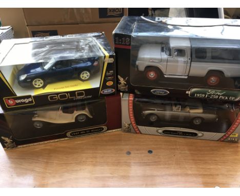 A collection of 1:18 scale boxed diecast vehicles including Burago Porsche 911, Aston Martin DB2, MG Midget and a Ford pick u