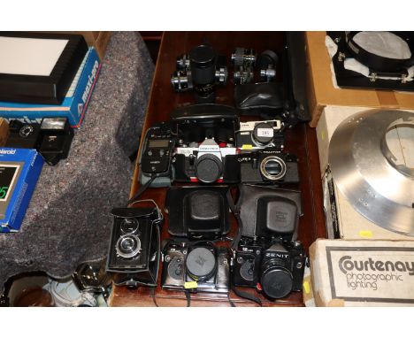 A quantity of various cameras and lenses to include Zenit, Practika, Canon, and a  Minolta flask meter 