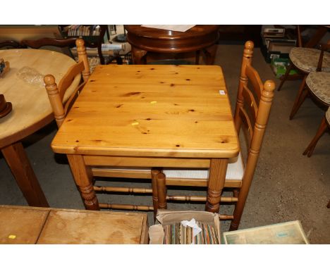 A pine table and two pine ladder back chairs 