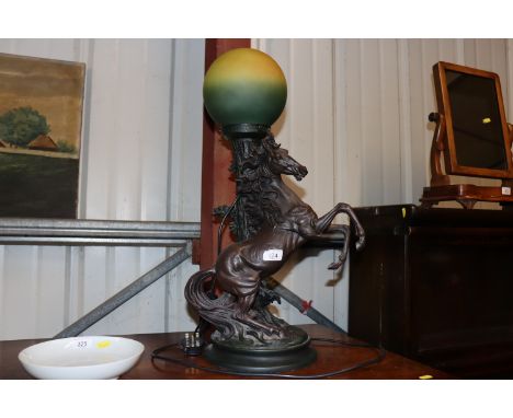 A bronzed table lamp decorated with rearing horse