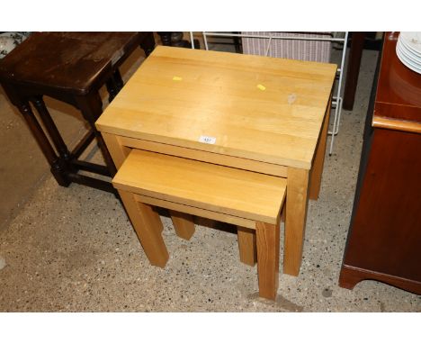 A nest of three modern light wood occasional tables 