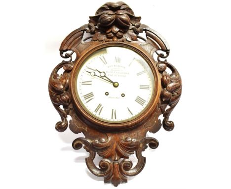 A LARGE WALL CLOCK IN HIGHLY CARVED OAK CASE  with 8-day movement, the 12' enamel dial with Roman numerals, inscribed 'geo. B