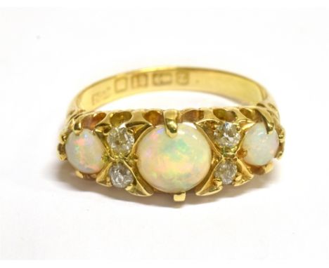 A VICTORIAN OPAL THREE STONE AND DIAMOND SET 18 CARAT GOLD RING  boat shaped claw set head, carved scroll shoulders, 18 carat