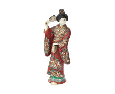  A Satsuma figure of a woman holding a fan and a lantern, first quarter 20th century. H. 29 cm.