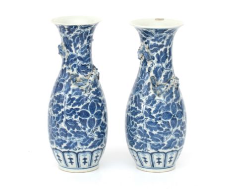  A pair of Chinese blue-and-white porcelain vases decorated with stylized flower and leaf motifs. With appliques of dragons c