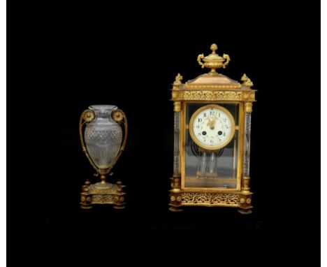  A richly decorated gilt brass and cut crystal column mantle clock wit gilt brass mounted vase, circa 1900. H. 41 cm.