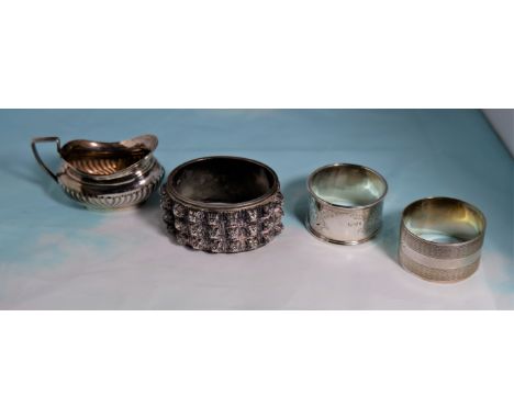 two silver napkin rings; a silver salt; a silver slave bangle (various dates) 4.5oz.; a pair of silver plated fish servers, t