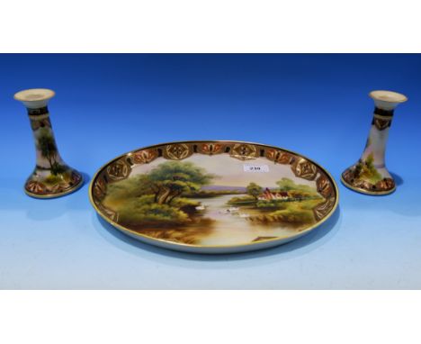 A Noritake oval dish hand painted with river scene and a pair of matching candlesticks