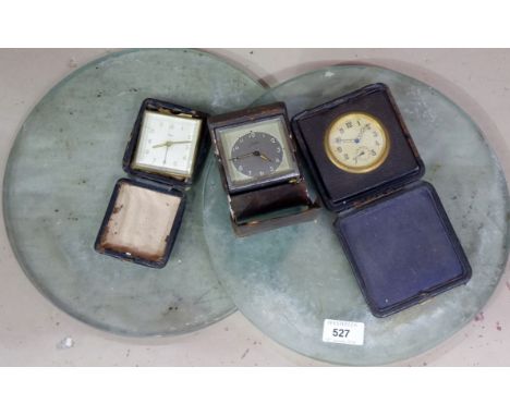 A Junghans cased alarm clock; 2 similar cased travelling clocks; 2 glass circular cutting boards