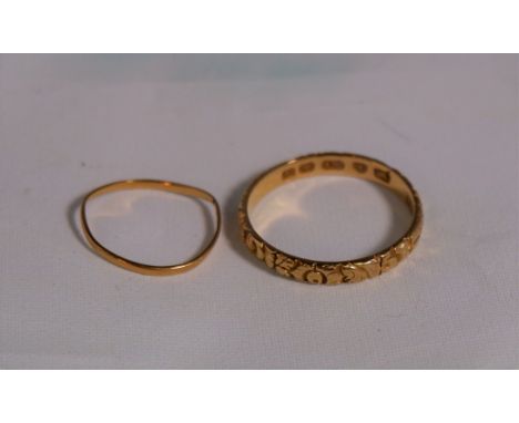 An 18 carat hallmarked gold wedding ring with relief scroll and flower decoration; a fine gold ring, marks worn, tests as 18c