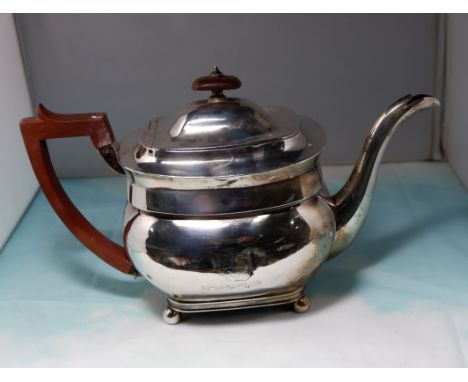 A Georgian silver teapot of rounded rectangular form, crested, on ball feet with boxwood handle, London 1805, 20 oz. (some de