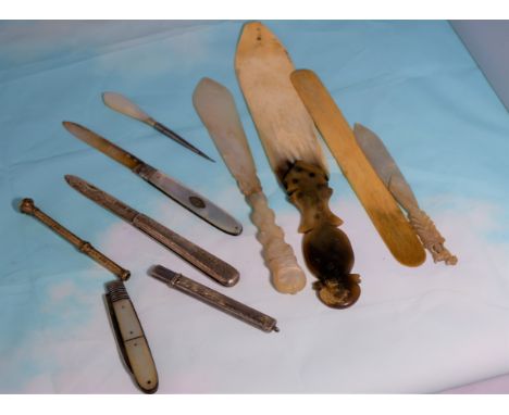 A chased gilt metal propelling pencil, various silver and mother of pearl pen knives, shoe horn etc