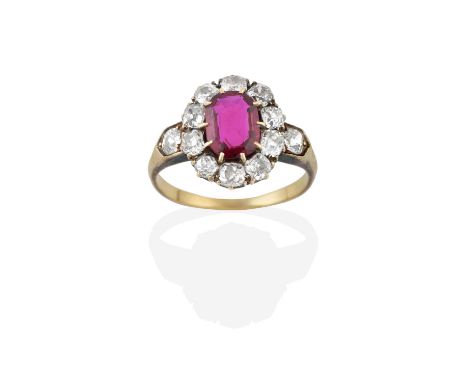 A Ruby and Diamond Cluster Ring, the oval cut ruby within a border of old cut diamonds, in yellow claw settings, to an old cu