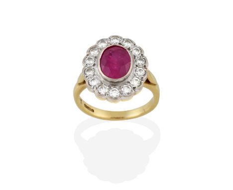 A Ruby and Diamond Cluster Ring, the oval cut ruby within a border of round brilliant cut diamonds, in white rubbed over sett