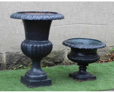 A LARGE CAST IRON URN of half fluted campana form with square base, 22" wide, 31" high, together with a similar smaller urn, 